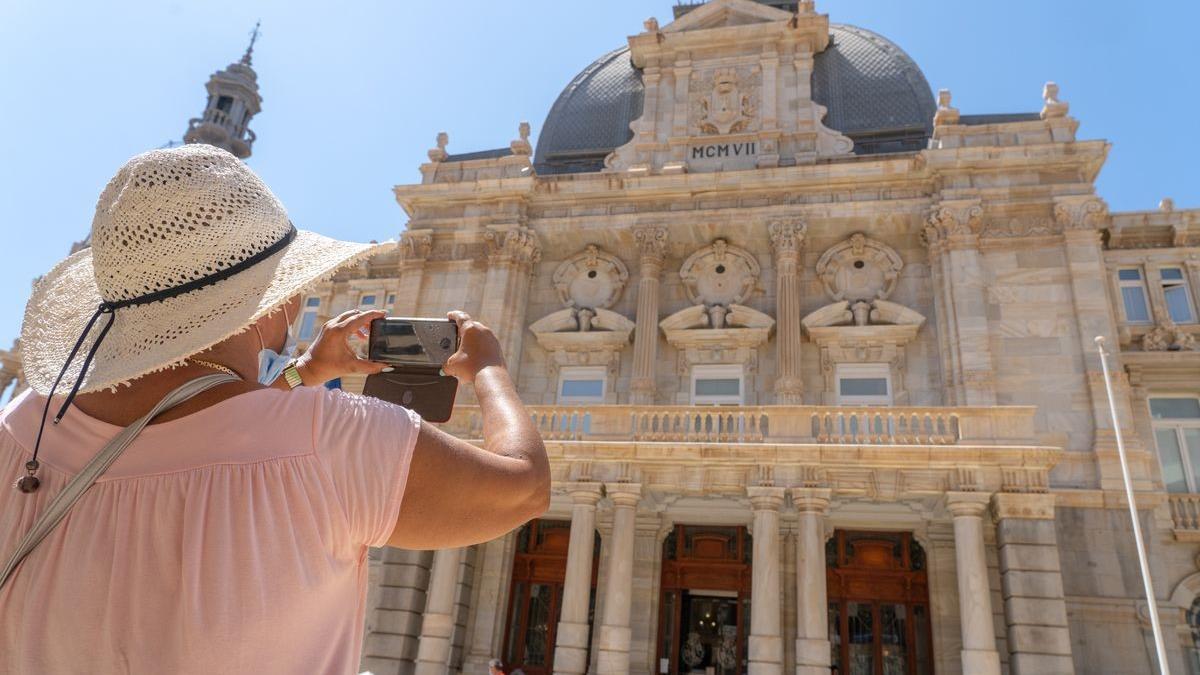 Una turista inmortaliza la fachada del Palacio Consistorial con su cámara.