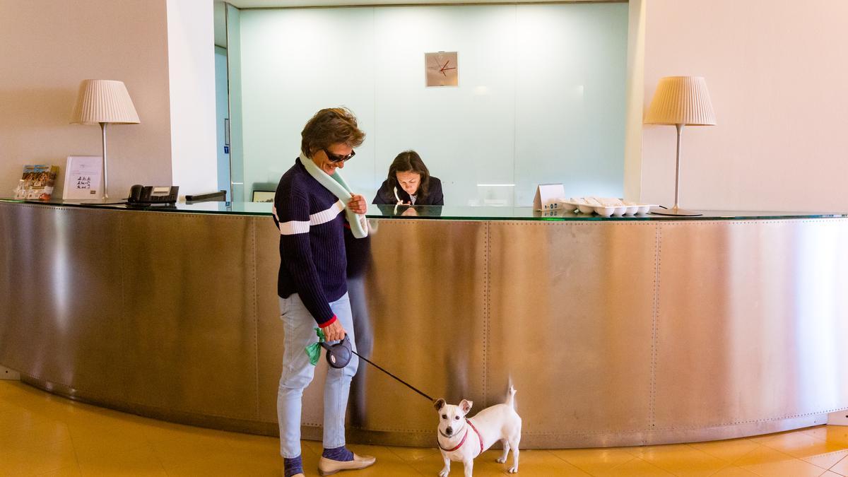 Un perro, junto a su humana, en la recepción de un hotel de Benidorm donde se admite la estancia de animales