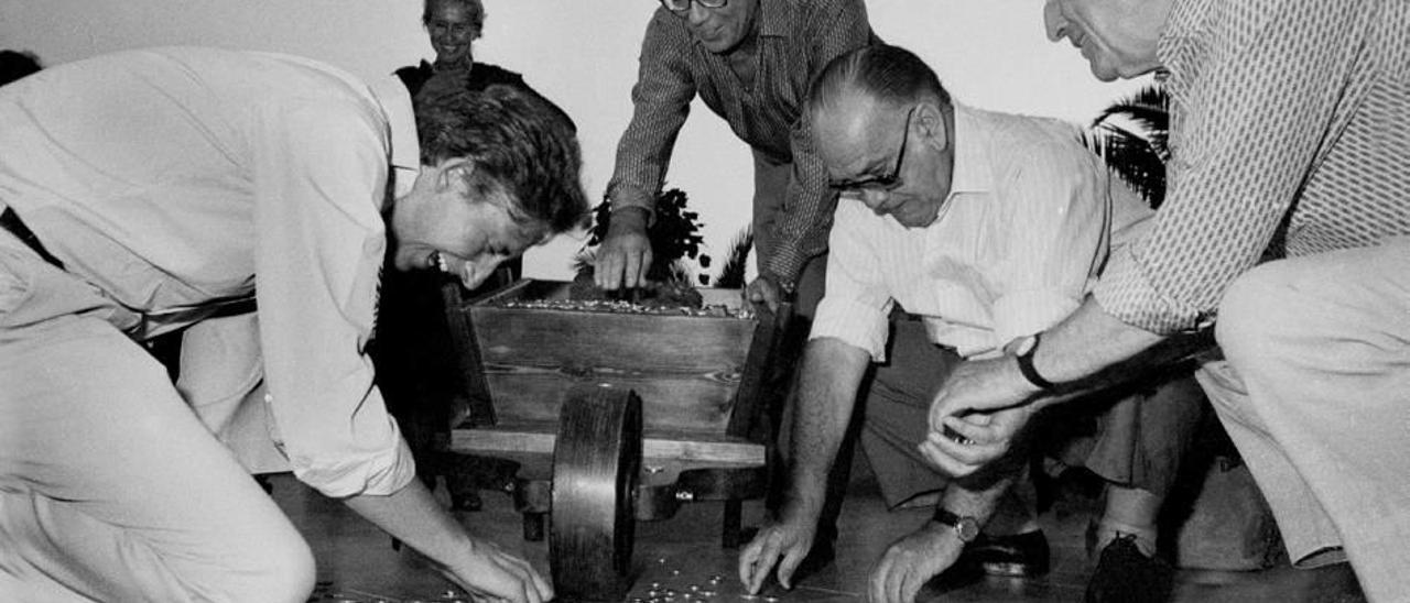 El escritor recogiendo las monedas del Premio Formentor junto a Alfonso Ussía y otros asistentes al galardón.