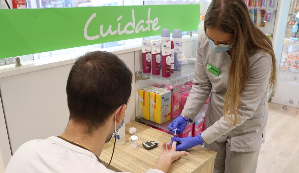 Una farmacéutica realiza el cribado de diabetes.
