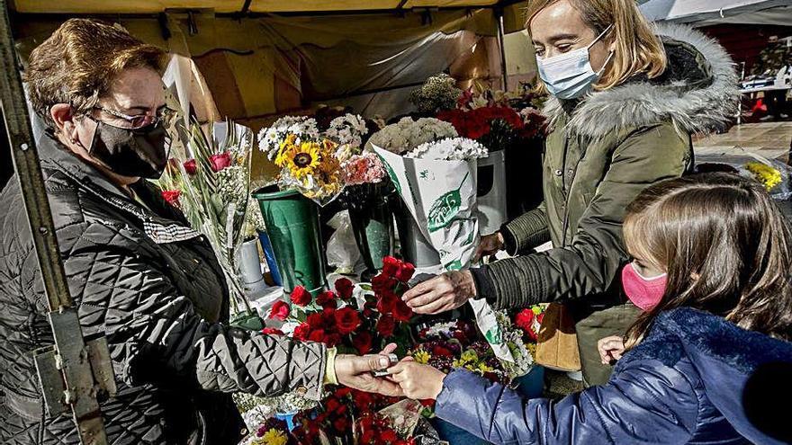 Adelaida Bedia, vendiendo flores a Isabel Menéndez, con su hija, Sofía Álvarez.