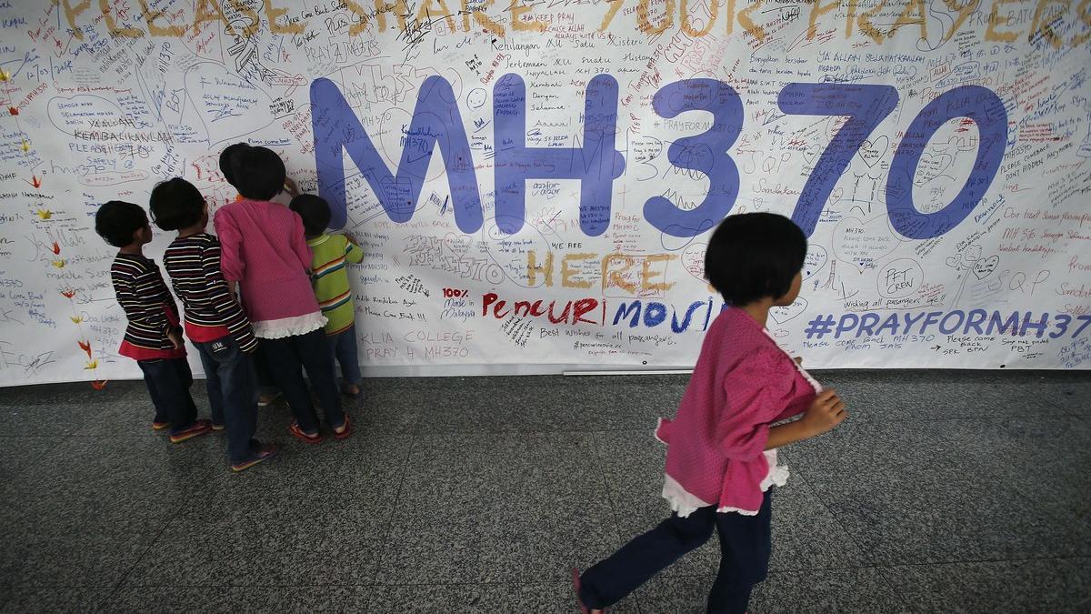 Un grupo de niños escribiendo mensajes esperanzadores para los familiares de las personas que desaparecieron en el vuelo MH370, de la compañía Malasya Airlines, en mayo del 2014.