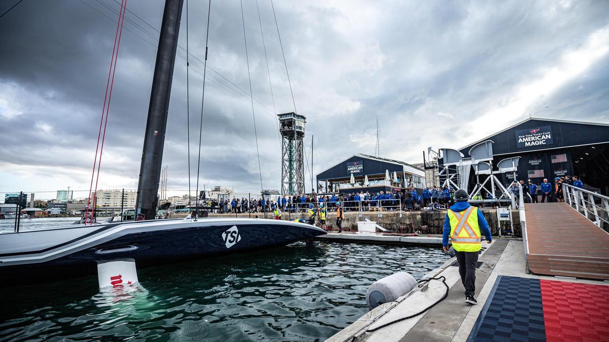 El 'Patriot', el AC75 del American Magic, equipo de la Copa América de vela, toca el agua por primera vez en el Port de Barcelona tras ser bautizado.