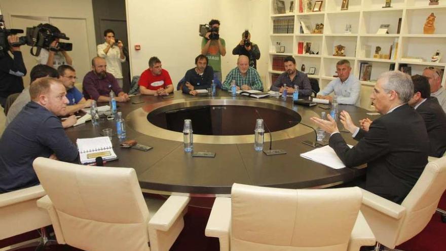 Los representantes de los trabajadores de Alcoa en Galicia, durante la reunión con el conselleiro de Economía, a la derecha de perfil.