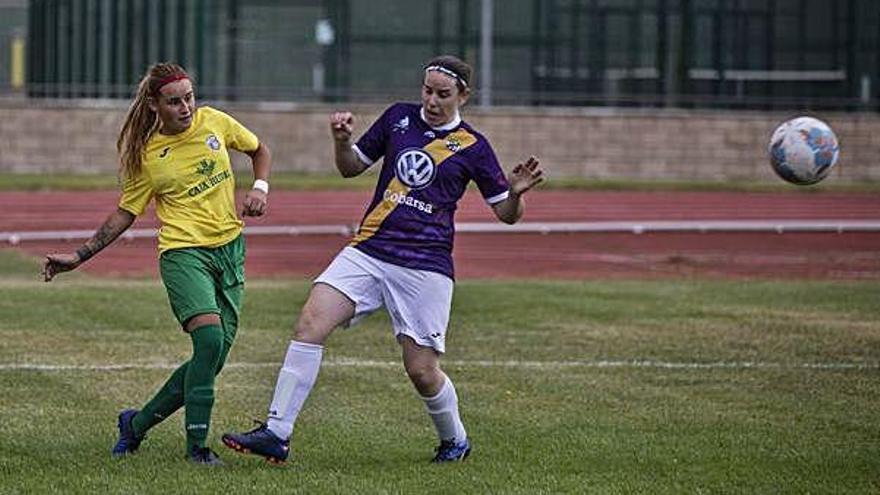 Una jugadora del Caja Rural despeja ante la presión de un rival.