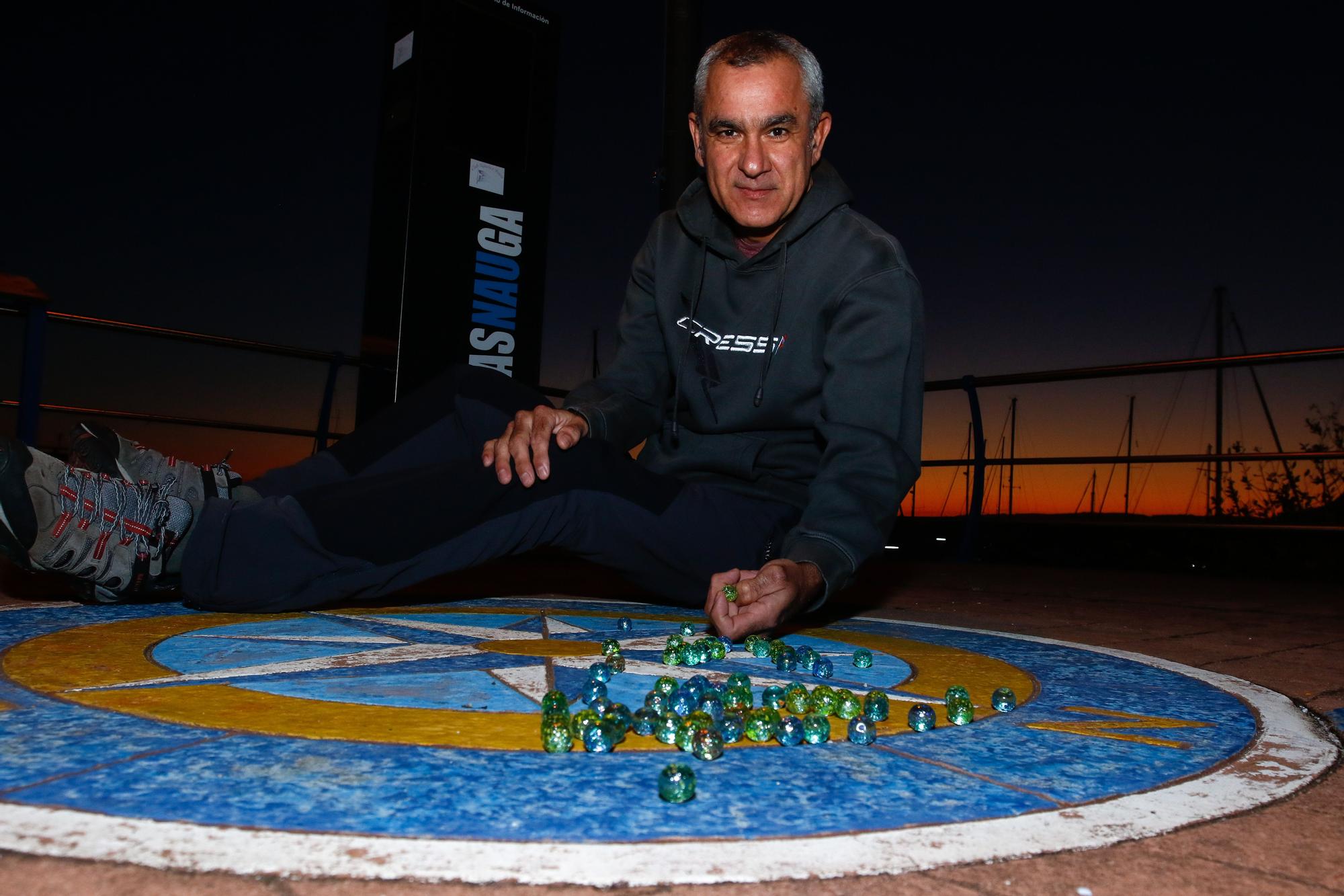 Jorge Candán muestra cómo jugaba a las canicas en el puerto deportivo Cabo de Cruz, en A Pobra