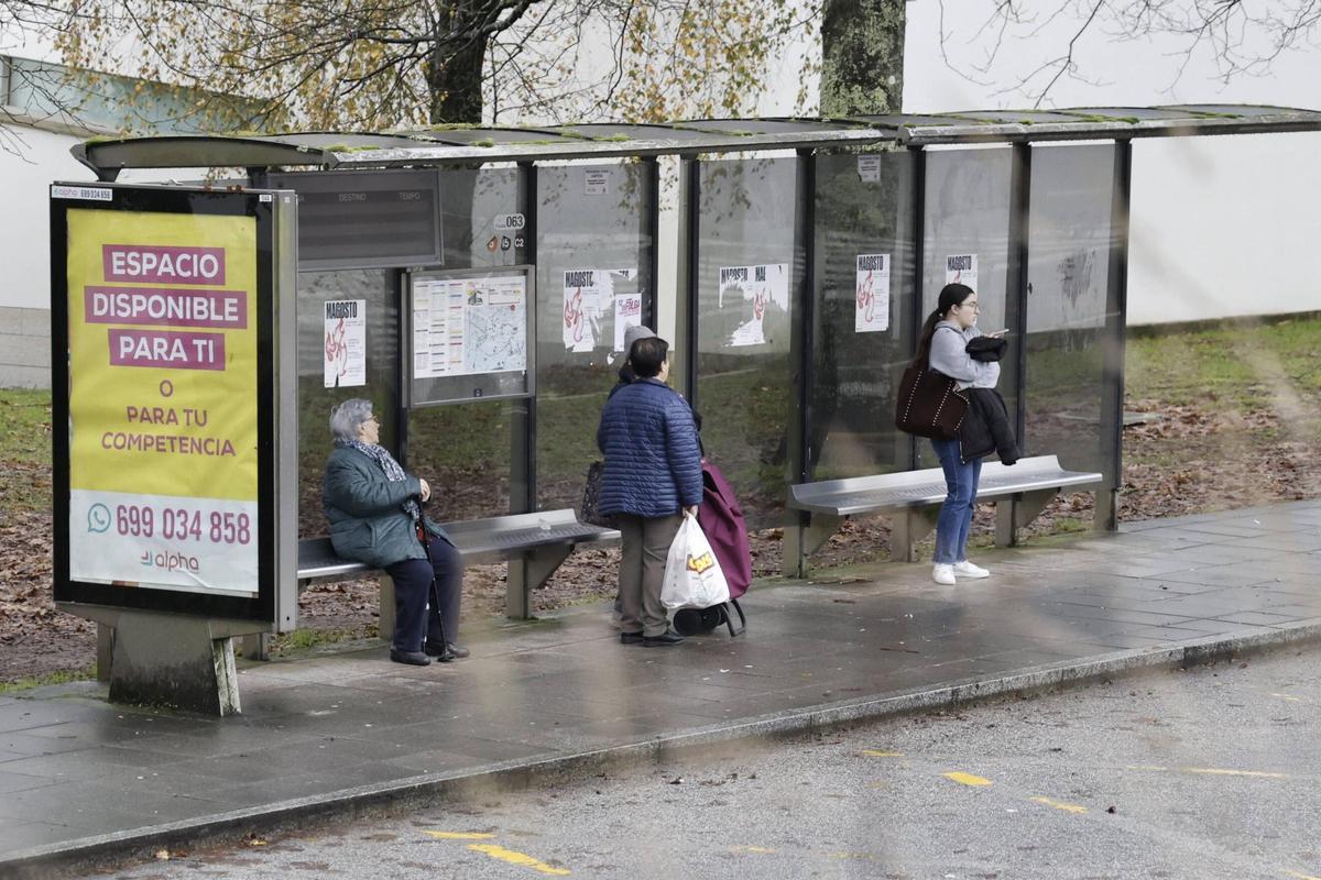 Personas esperando este viernes el autobús en la parada 63 de la avenida Castelao de Santiago