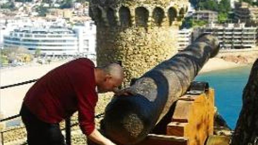 Un operari treballa en la restauració de la base d&#039;un canó de Tossa.