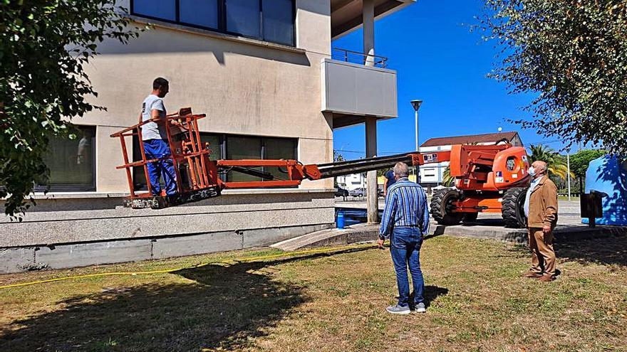 El alcalde Andrés Iglesias (d.) supervisa la renovación de fachada.