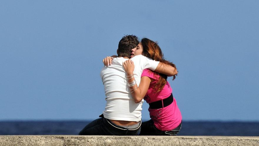 Una pareja se abraza en el muro del malecon de La Habana.