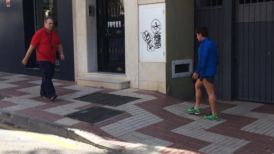 Dos peatones pasan por delante de una pintada en una calle del centro de Marbella.