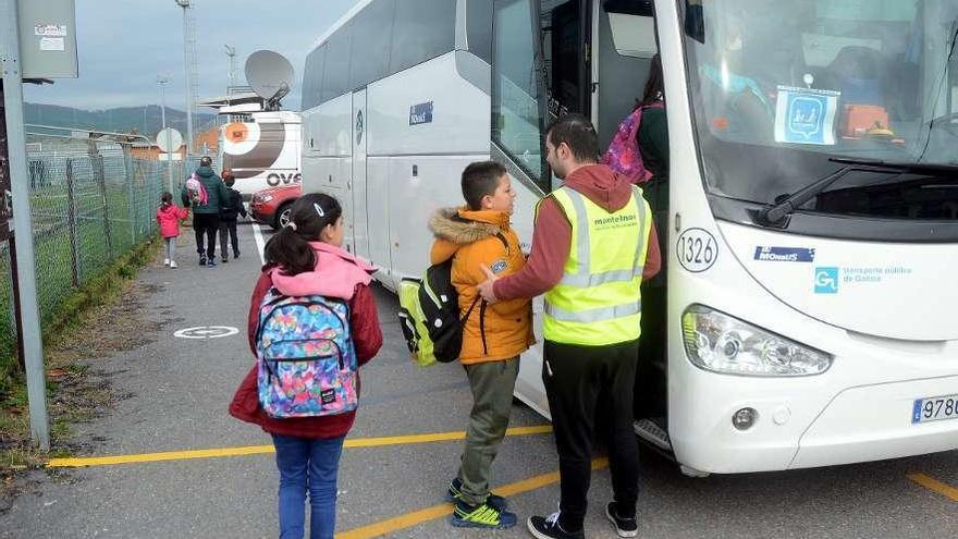 Alumnos suben a un autobús escolar.