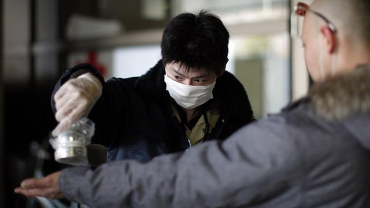 Un médico comprueba los niveles de radiación a un vecino del área de Fukushima, el miércoles, en un centro para evacuados.