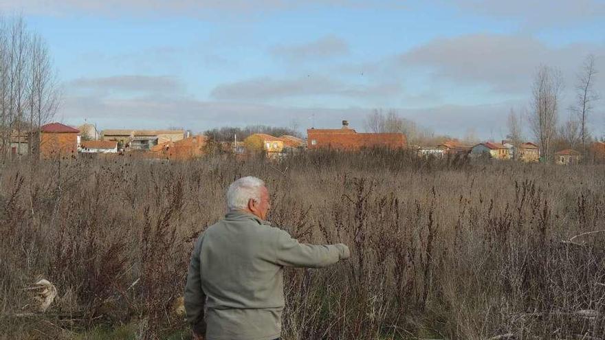 Un vecino señala la parcela elegida para construir el cementerio.