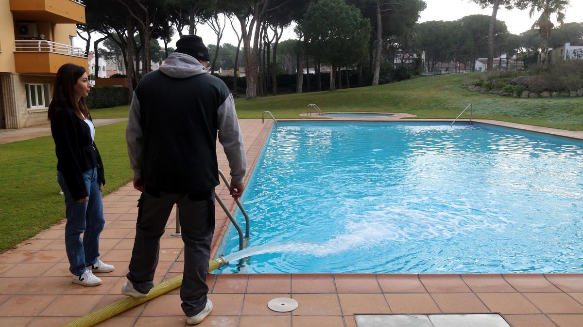 Dues persones omplint una piscina.