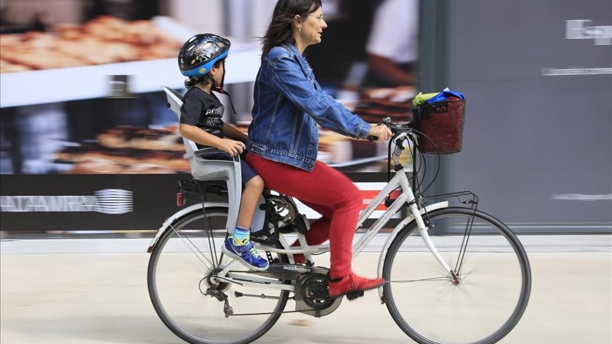 Una madre con su hijo en bicibleta por el barrio de Poblenou