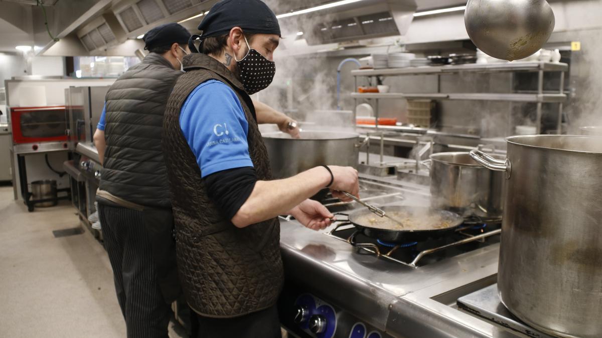 Pla general de dos cuiners del restaurant Els Caçadors de Ribes de Freser (Ripollès) treballant el desembre del 2021.(Horitzontal)