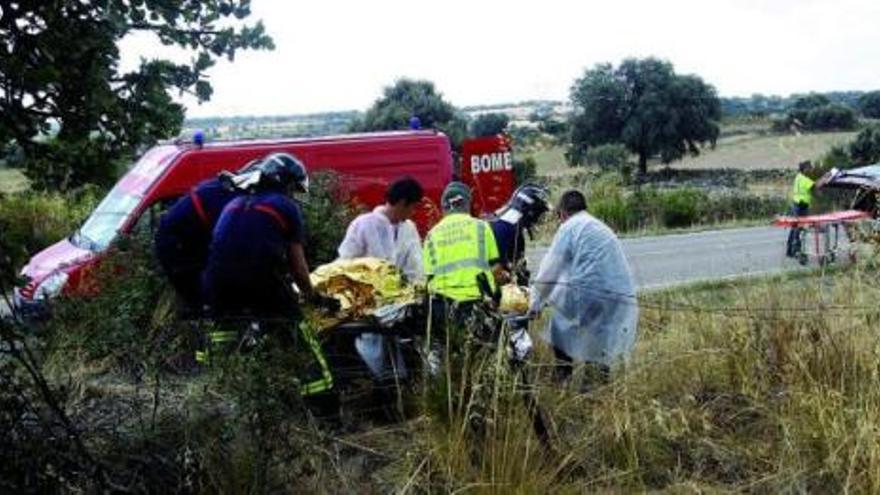 Los bomberos y servicios sanitarios retiran el cuerpo de la joven del lugar del accidente.