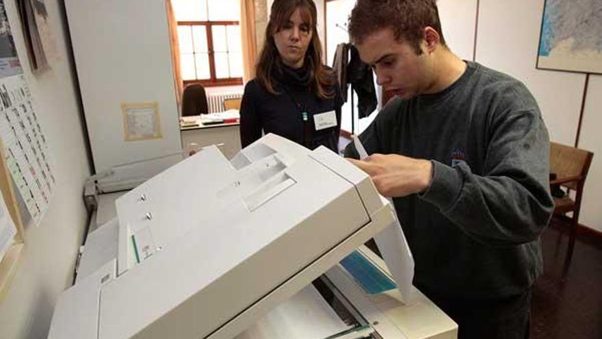 Guillermo Fernández hace fotocopias, supervisado por María José Reyes, en el colegio.