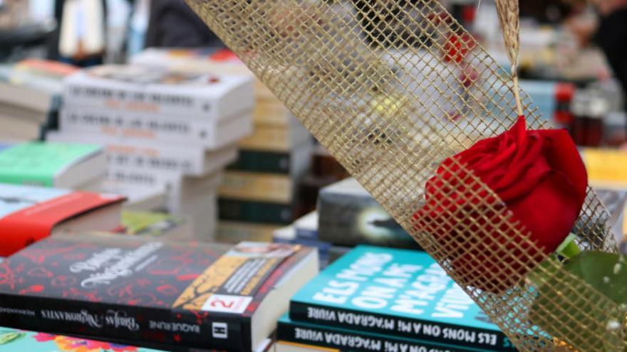 Una parada de llibres de Sant Jordi amb una rosa en primer pla