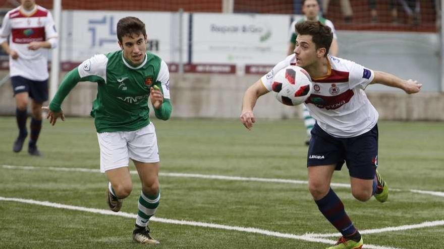 Iván Suárez controla el balón con el pecho ante la presencia de Riki.