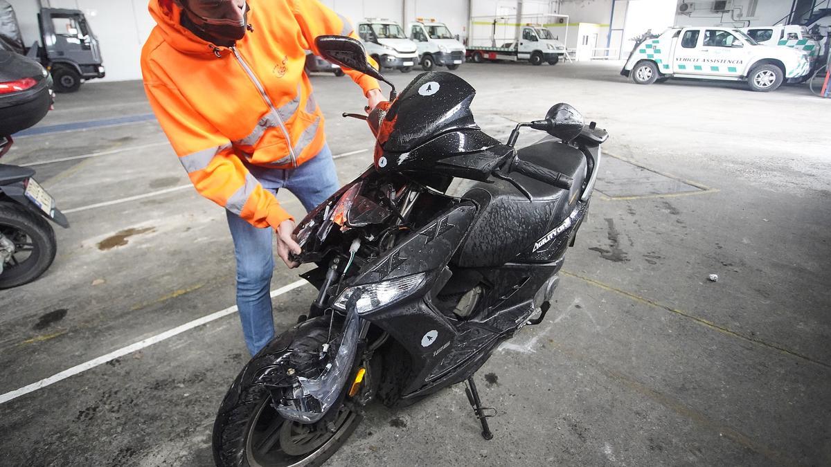 Un empleat de Grues Cruz mostrant la moto sinistrada d&#039;Aiguaviva