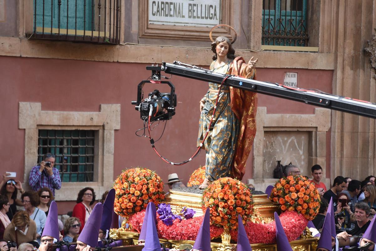 Una cámara de televisión se acerca para grabar un detalle de San Juan a su paso por Belluga en el Viernes Santo de Murcia.