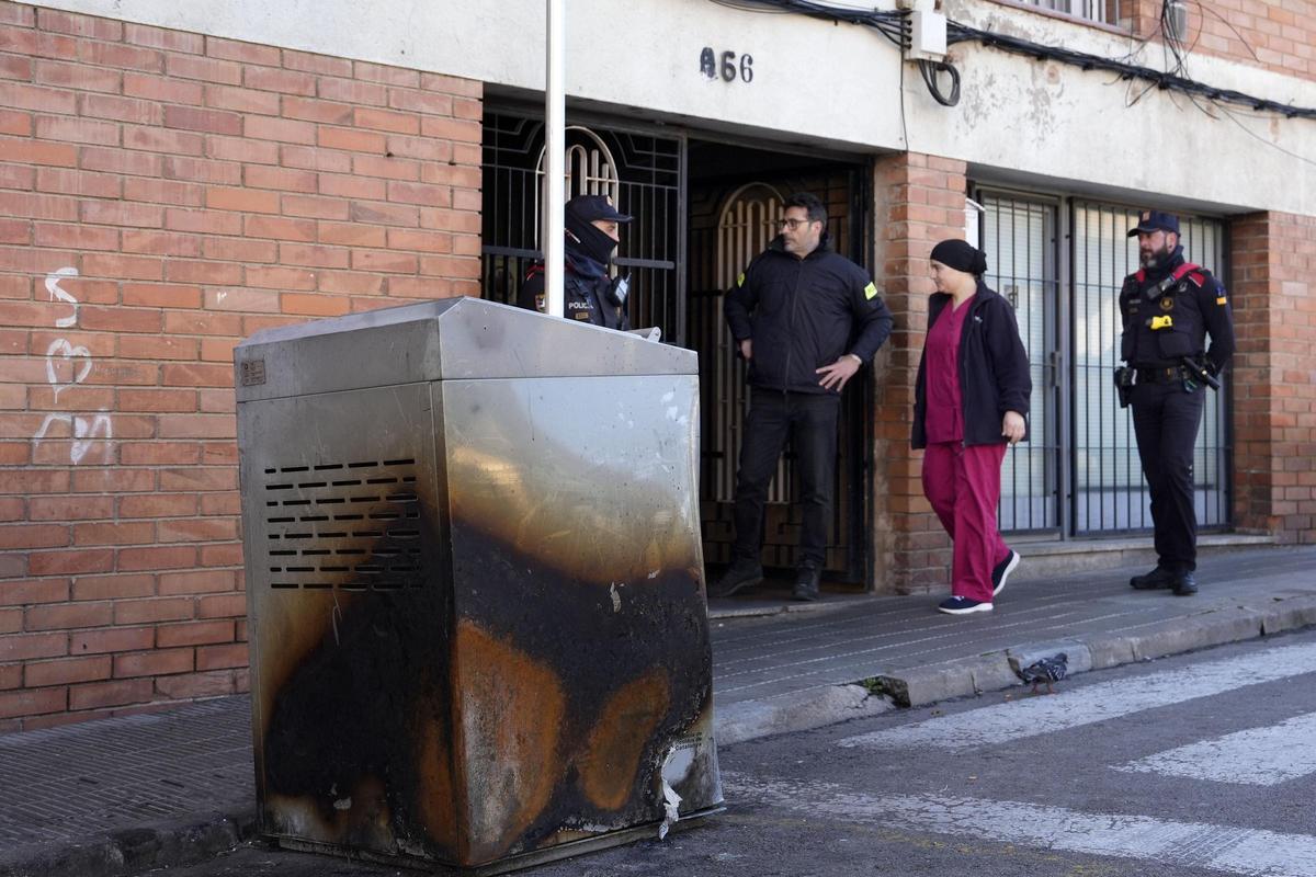 Varios mossos d'esquadra en la puerta del edificio de Manlleu (Barcelona) en cuya azotea se encontraba el trastero en el que anoche fallecieron cinco adolescentes