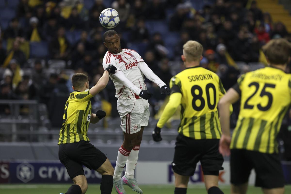 ASTANA (Kazakhstan), 09/12/2025.- Dan Glazer (L) of Kairat Almaty in action against Ayoub El Kaabi (C) of Olympiacos during the UEFA Champions League soccer match between Kairat Almaty and Olympiacos, in Astana, Kazakhstan, 09 December 2025. (Liga de Campeones, Kazajstán) EFE/EPA/STRINGER. kairat . olympiacos. liga campeones 2025/2026 kairat . olympiacos. 06. accion. astana arena