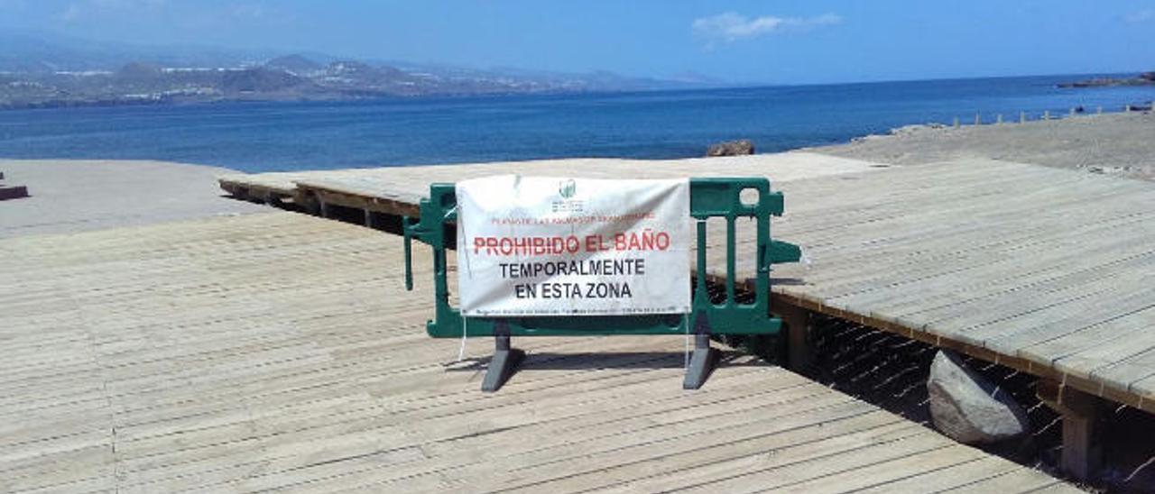 Vista de la playa de El Confital, con el cartel de prohibido el baño.