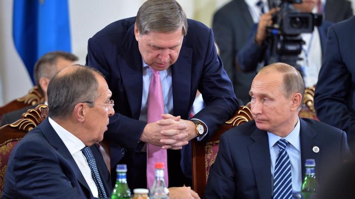 Putin (derecha), el ministro ruso de Exteriores, Serguéi Lavrov (izquierda), y un asistente del presidente, Iuri Ushakov, en una reunión en Ereván (Armenia), este viernes.