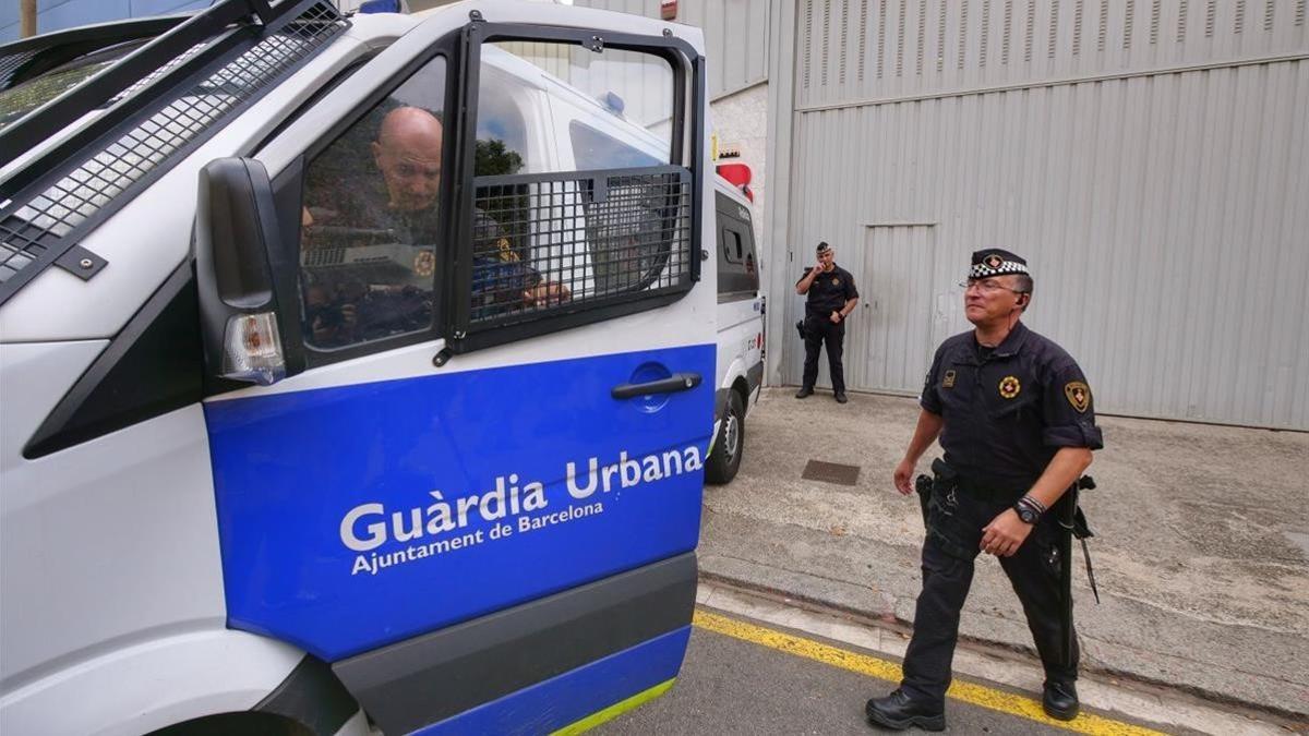 Agentes de la Guardia Urbana custodiando el almacén de la calle Perú.