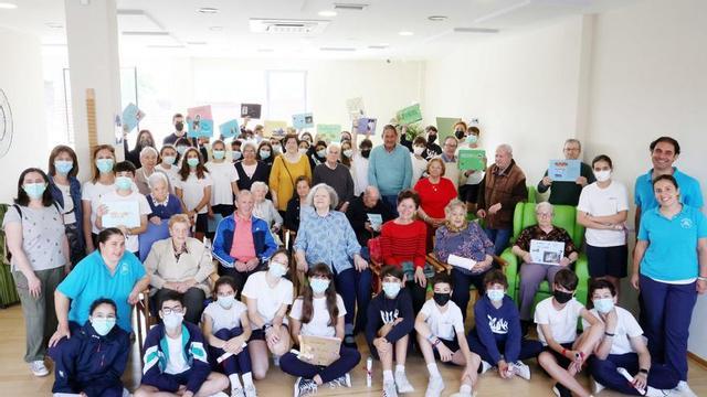 Arriba, foto de familia. Abajo, un niño enseña fotos  a un usuario.         | MARTA G. BREA