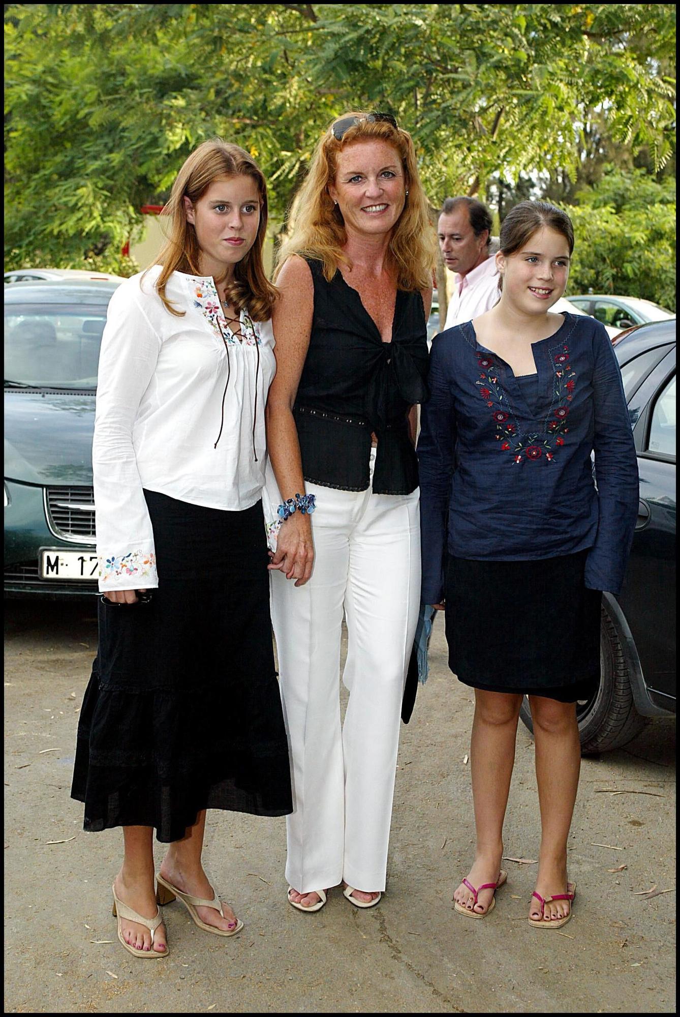 Sarah Ferguson junto a sus dos hijas, Eugenia y Beatriz de York, en un evento en 2002