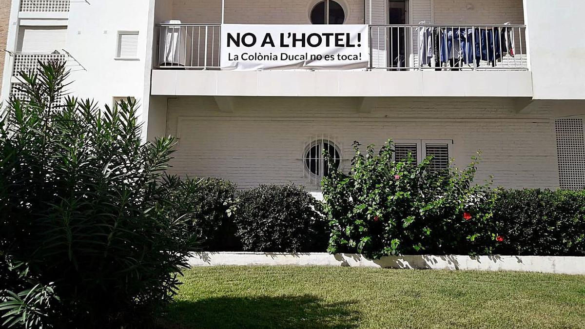 Una de las pancartas contra el hotel, en un balcón de la Colonia Ducal de la playa de Gandia. | LEVANTE-EMV