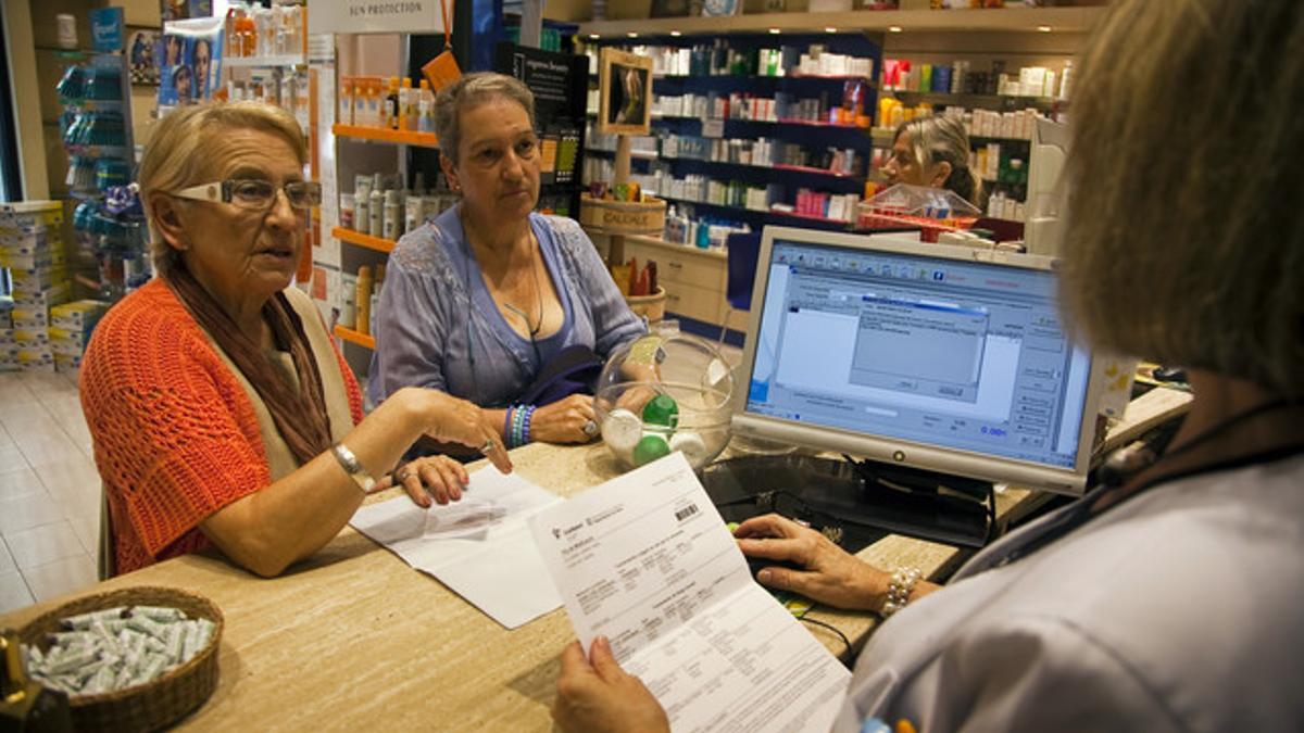 Entrada en vigor del copago sanitario catalán, en una farmacia de Barcelona, el julio pasado.