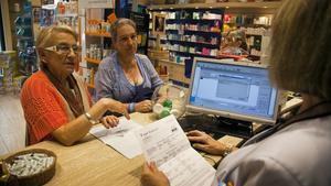 Entrada en vigor del copago sanitario catalán, en una farmacia de Barcelona, el julio pasado.