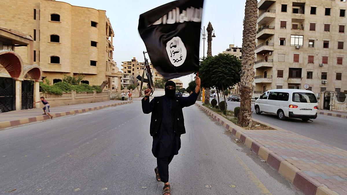 Un yihadista ondea una bandera del Estado Islámico en Raqqa (Siria).