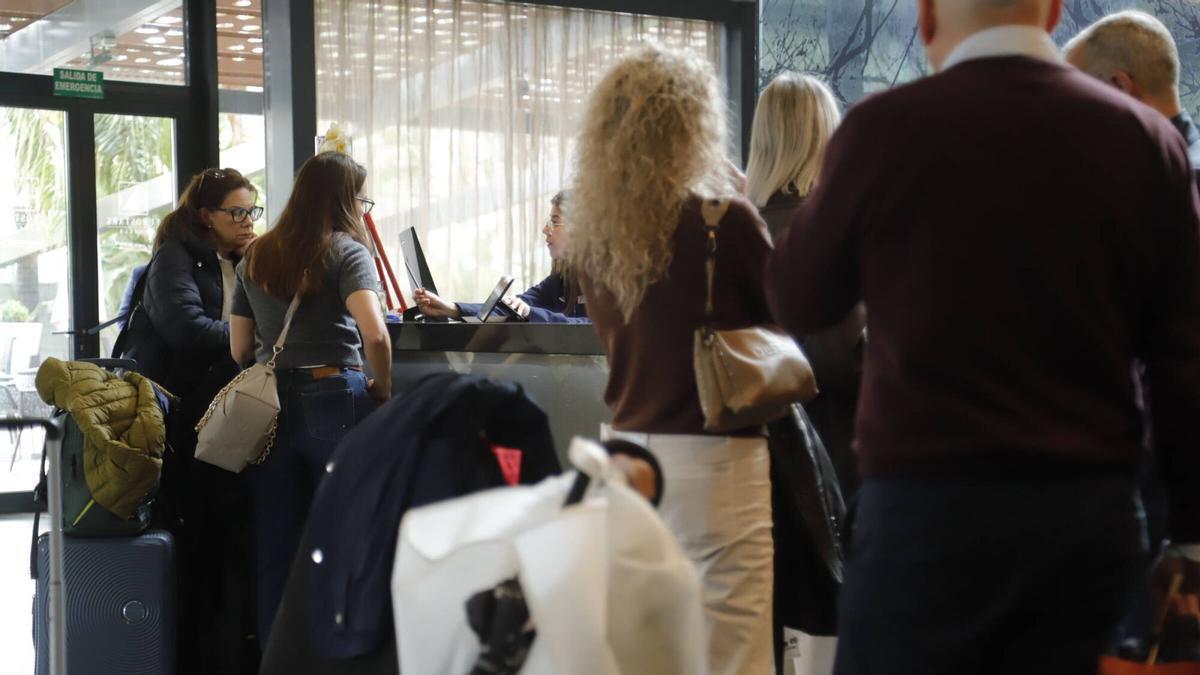 Turistas son atendidos en la recepción de un hotel en Córdoba.