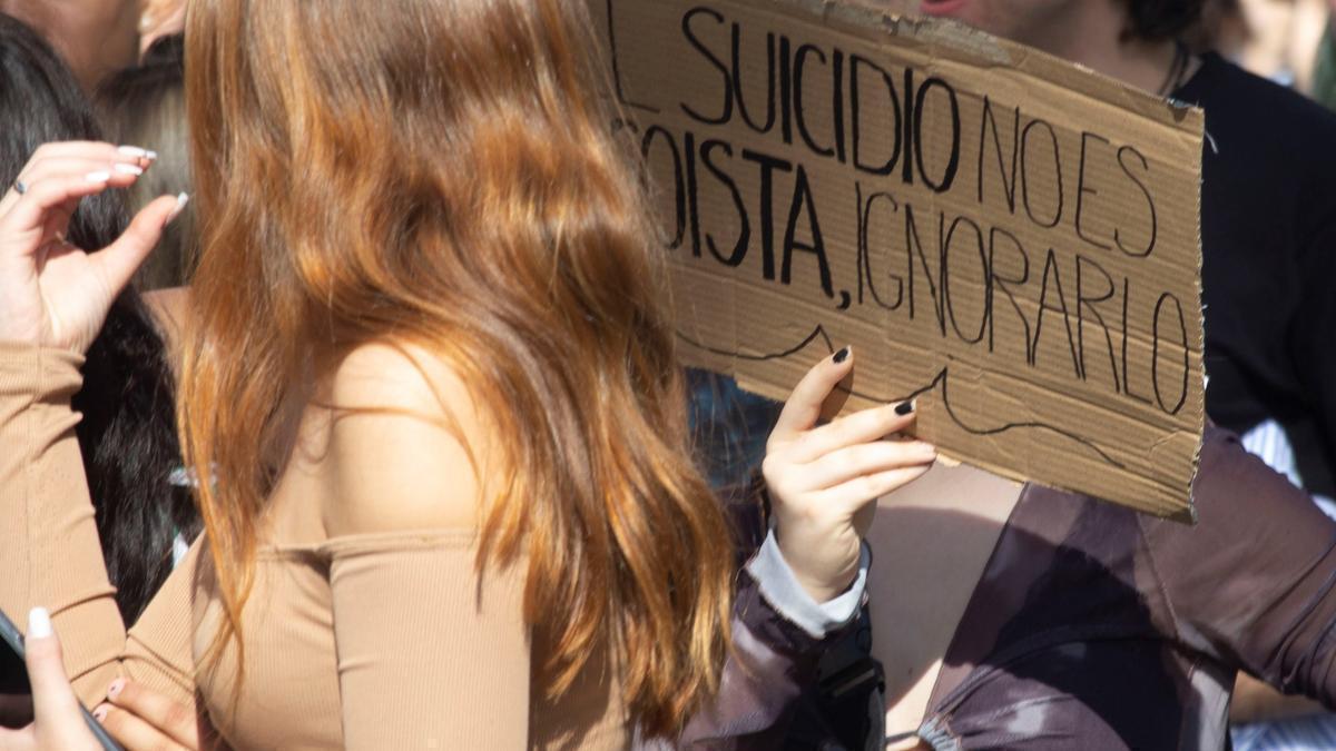 Mensajes para visibilizar el suicidio en una manifestación de jóvenes en favor de la salud mental.