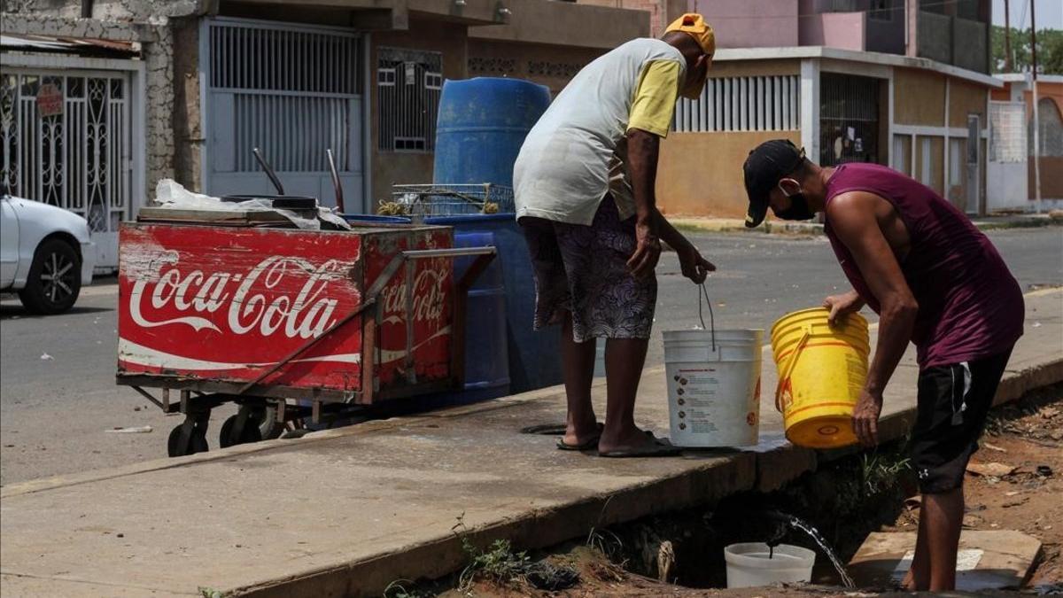 Venezolanos recogen agua en la ciudad de Maracaibo.