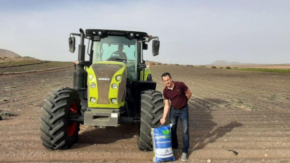 El consejero Hugo Delgado, con uno de los sacos para sembrar. | |