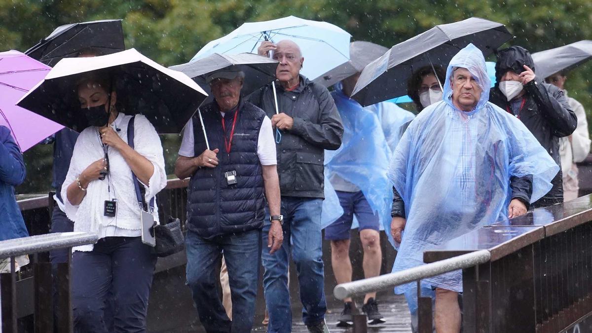 Diversos turistes sota la pluja, a la ciutat de Girona.