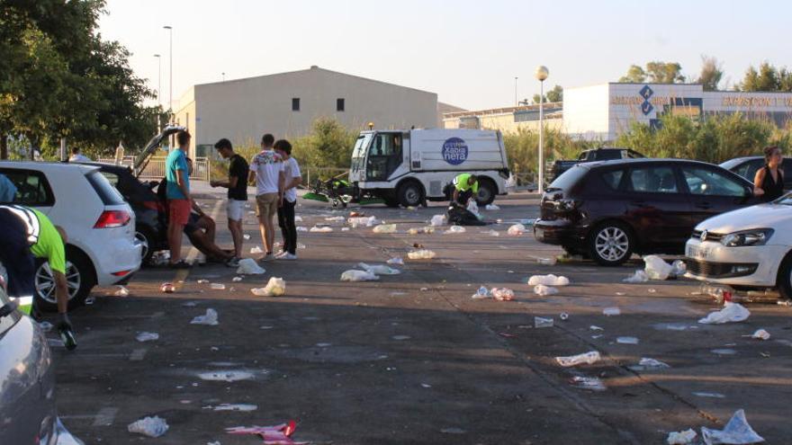 Los jóvenes apuran la fiesta mientras los operarios quitan basura y la barredora limpia el aparcamiento público junto al Gorgos.