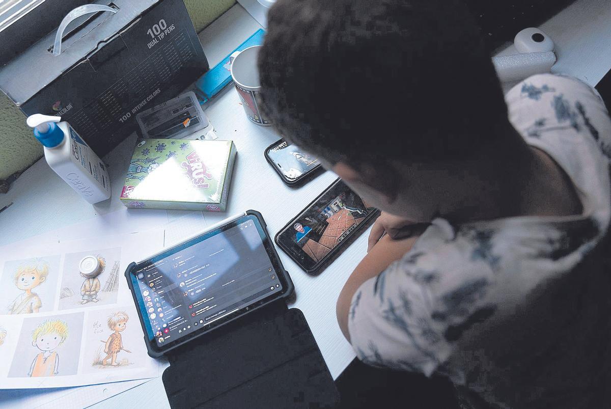 Un menor hace uso de un móvil y de una tablet, en una imagen de archivo.