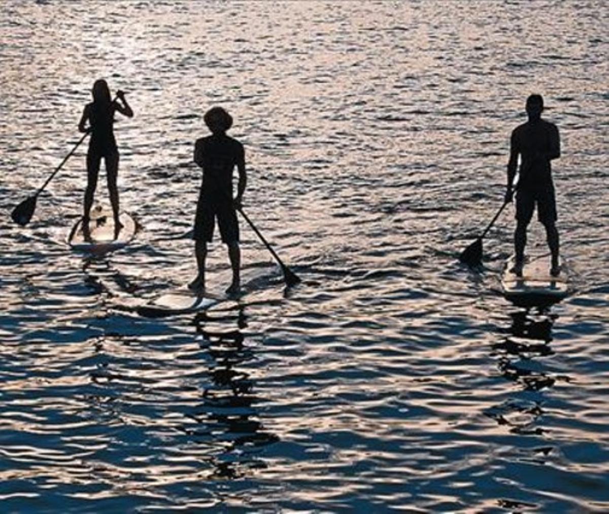 Un home i una dona practiquen paddlesurf en aigües de la Barceloneta, el 7 d’agost. Un home i una dona practiquen paddlesurf en aigües de la Barceloneta, el 7 d’agost.