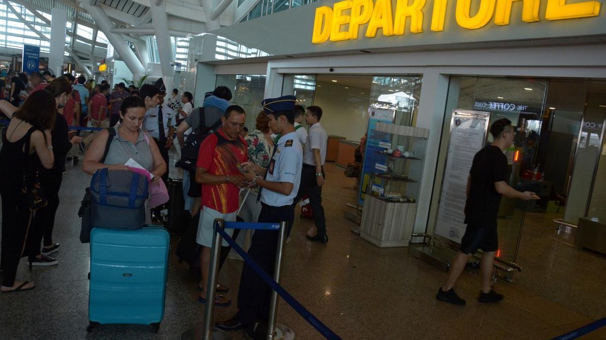 Pasageros haciendo cola en el aeropuerto Ngurah Rai de la isla de Bali, después de que retomara su actividad.