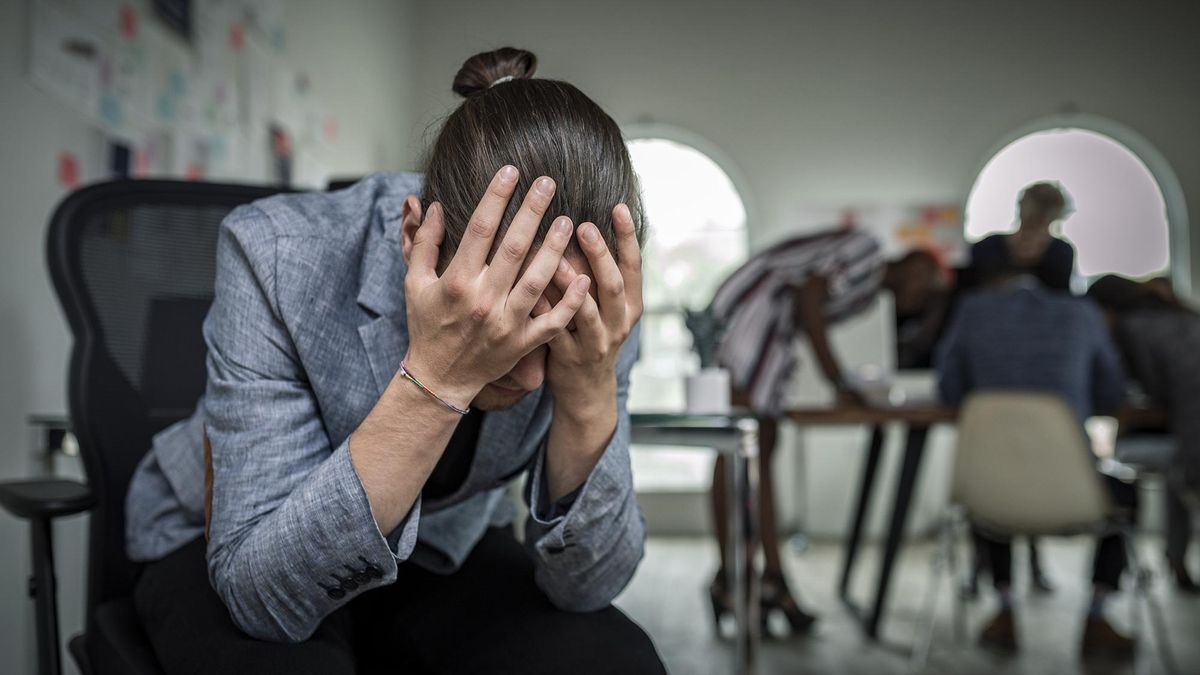 Un hombre con un ataque de ansiedad en una oficina