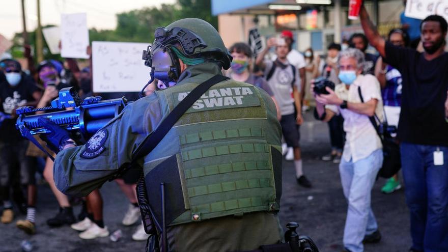 Un agent de policia apunta contra manifestants en una protesta per la mort de Rayshard Brooks a Atlanta