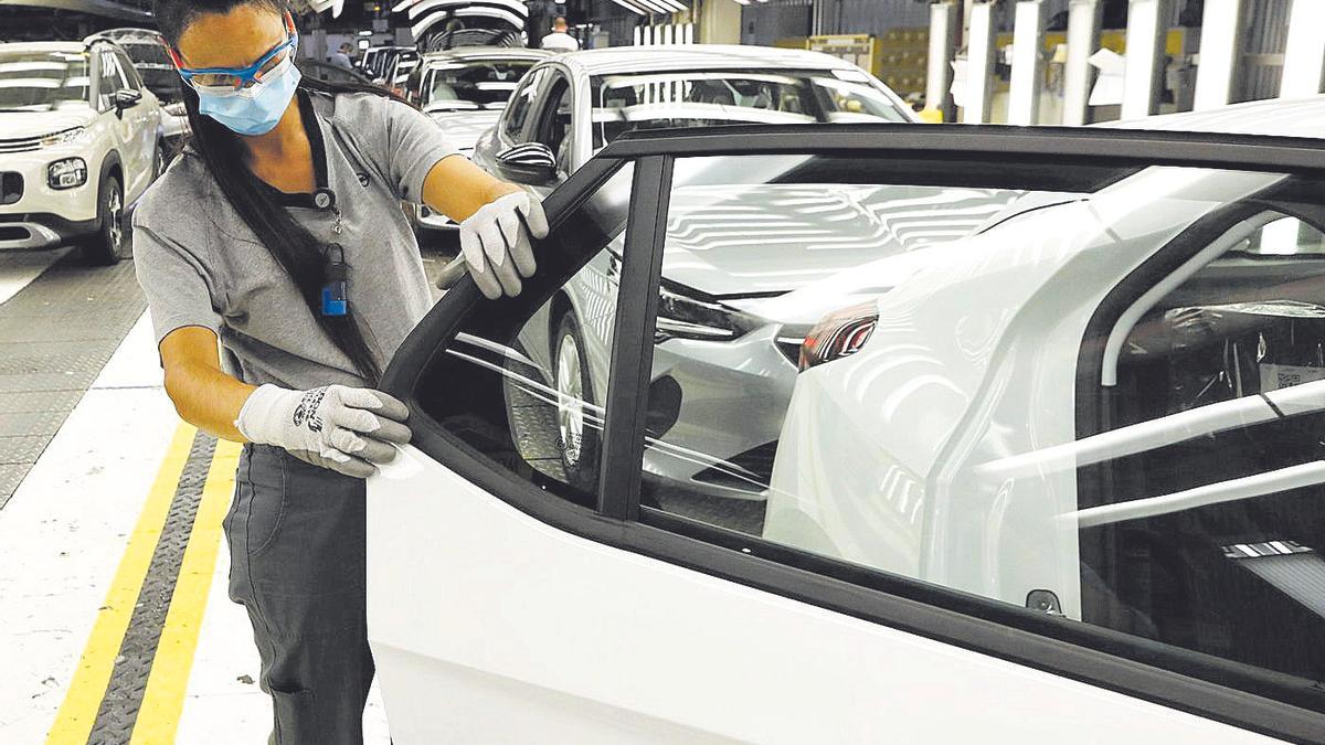 Una trabajadora en plena faena en una línea de montaje de la planta automovilística de Stellantis en Figueruelas.